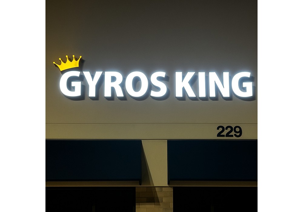 Illuminated white channel letters reading Gyros King mounted on a storefront at night